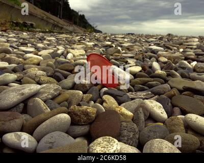 Contre l'encrassement plastique de la masse. Plastique coupe s'écroule et jeté sur la plage de galets de la mer Banque D'Images