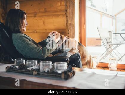 La scène tendre avec une femme et son chien de beagle dans une confortable maison de campagne confortable. Vacances à la campagne avec animaux de compagnie Banque D'Images