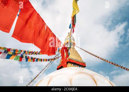 Drapeaux de prière multicolores avec textes de mantras articulé sur le dessus de Boudhanath Stupa, la plus grande stupas sphérique au Népal Banque D'Images