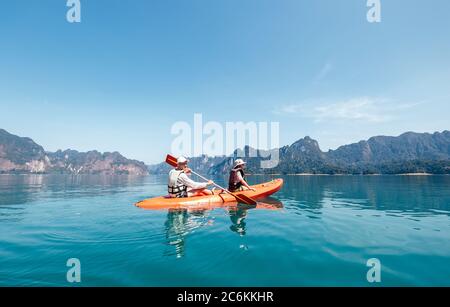 Père et fils pagayant ensemble en kayak sur le lac Cheyw LAN en Thaïlande. Image concept vacances avec enfants. Banque D'Images