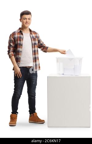 Portrait complet d'un jeune homme qui vote dans une boîte électorale et regarde la caméra isolée sur fond blanc Banque D'Images