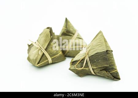 Vue rapprochée du zongzi, c'est un plat traditionnel chinois de riz à base de riz gluant farci avec différentes garnitures et enveloppé dans des feuilles de roseau. Banque D'Images