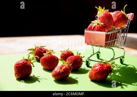 Panier rempli de fraises fraîches isolées sur des fraises vertes. Des fraises parfumées bio sucrées dans un mini-panier pour faire du shopping Banque D'Images