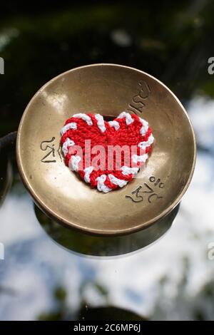Instrument sonore Zimbel pour la détente avec un coeur rouge crocheté. Banque D'Images