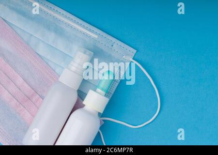 masques chirurgicaux et spray désinfectant pour les mains pour une protection de la diffusion pour l'hygiène des mains. Concept de prévention des coronavirus. Fond bleu . Gros plan Banque D'Images