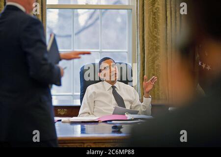Le président Barack Obama est informé avant de faire des appels téléphoniques avec les dirigeants étrangers dans le bureau ovale 1/26/09. Banque D'Images