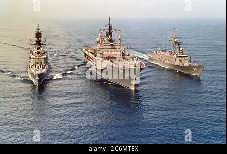 Officiers et marins les rails de l'homme commande amphibie USS Blue Ridge (LCC-19), navire amiral de la 7e Flotte, flanqué par le croiseur lance-missiles USS STERETT (CG-31), à gauche, et la frégate lance-missiles USS RODNEY M. DAVIS (FFG-60) Banque D'Images