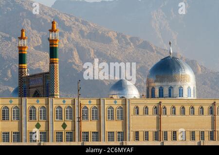 École pour clercs à Kermanshah. Vue de détail sur une partie de l'est complexe avec 2 minarets jaune avec bandes vert et coupole en raison de montagnes en c Banque D'Images