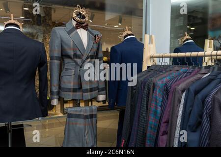 Vestes pour hommes sur cintres dans le magasin pour hommes. Rangée de vestes de costume pour hommes suspendues dans le placard. Vitrine Banque D'Images