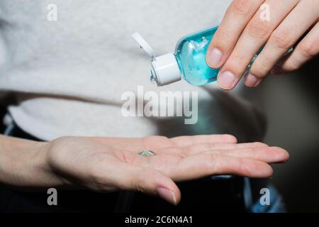 Assainisseur antiseptique dans les mains. Elle traite ses mains avec un agent antibactérien. Banque D'Images