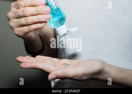 Assainisseur antiseptique dans les mains. Elle traite ses mains avec un agent antibactérien. Banque D'Images