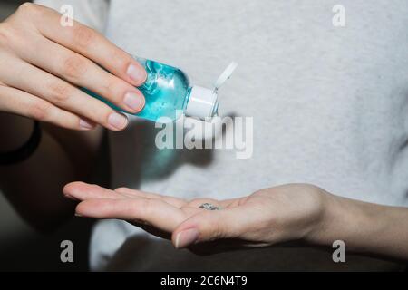 Assainisseur antiseptique dans les mains. Elle traite ses mains avec un agent antibactérien. Banque D'Images