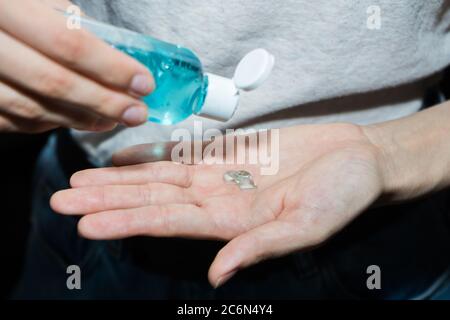 Assainisseur antiseptique dans les mains. Elle traite ses mains avec un agent antibactérien. Banque D'Images