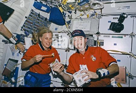 (7 - 19 août 1997) --- pendant les heures de travail des astronautes N. Jan Davis, commandant de charge utile, et Stephen K. Robinson, spécialiste de mission, essayez leurs mains sur des baguettes tout en prenant un repas de riz japonais sur le pont intermédiaire de la navette spatiale Discovery. L'astronaute Curtis L. Brown, Jr., commandant de mission, est partiellement hors de cadre à gauche. Banque D'Images