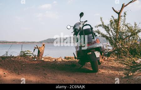 Un scooter est stationné sur la côte de la mer ou de l'océan. Banque D'Images