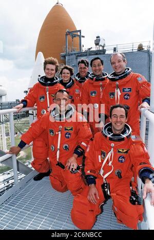 1997 - portant leurs espaces orange de lancement et d'entrée, les membres de l'équipage STS-84 sont tous souriants alors qu'ils posent pour une photo de groupe au Launch Pad 39A avec la navette spatiale Atlantis en arrière-plan. Les spécialistes de mission Jean-François Clervely, à droite, de l'Agence spatiale européenne, et Carlos I. Noriega sont à genoux devant nous. Debout, de gauche à droite, se trouvent Elena V. Kondakova, spécialiste de mission de l'Agence spatiale russe, Eileen Marie Collins, C. Michael Foale et Edward Tsang lu, spécialistes de mission, et Charles J. Precourt, commandant de mission. Banque D'Images