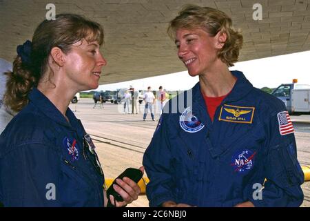 CENTRE SPATIAL KENNEDY, FLA. -- Pamela A. Melroy, membre de l’équipe de soutien aux astronautes (à gauche), salue la pilote STS-94 Susan L. toujours sous l’orbiteur de la navette spatiale Columbia après un atterrissage en fin de mission sur la piste 33 de l’installation d’atterrissage de la navette de KSC le 17 juillet pour terminer la mission du Laboratoire scientifique de microgravité 1 (MSL-1). Banque D'Images