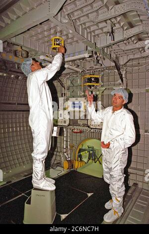 Stephen K.Robinson, spécialiste de mission STS-95 (à gauche), examine l'équipement du module SPACEHAB, tandis que Chris Jaskolka, de Boeing SPACEHAB, explique l'équipement lors d'une visite de familiarisation de l'équipage STS-95 à l'installation de traitement de la charge utile SPACEHAB à Cape Canaveral, en Floride Banque D'Images