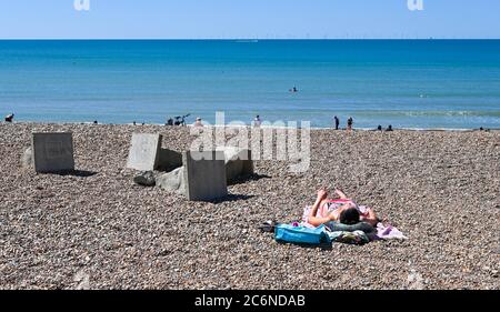 Brighton Royaume-Uni 11 juillet 2020 - UN soleil fait le meilleur du beau temps ensoleillé sur la plage de Brighton aujourd'hui : crédit Simon Dack / Alamy Live News Banque D'Images