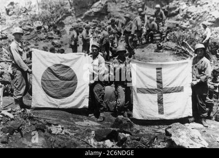 Des membres de la Compagnie F, 147e infanterie, ont capturé des drapeaux japonais trouvés dans un hôpital souterrain, le 11 avril 1945. Soulageant les unités du corps des Marines, les soldats du 147e Régiment d’infanterie de la Garde nationale de l’Ohio ont combattu sur l’île de mars à septembre 1945, libérant les troupes ennemies restantes, dont certains se cachaient dans des systèmes de grottes complexes Banque D'Images