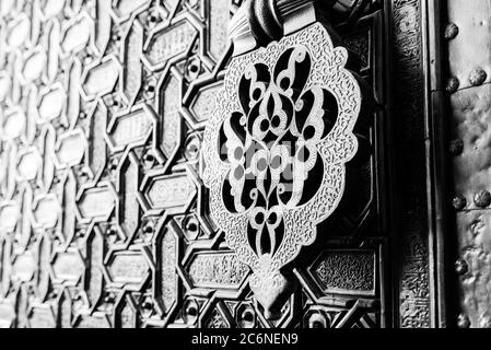 Détail d'un heurtoir islamique et des ornements à l'extérieur de l'une des principales portes de la Cathédrale de Séville, Espagne. Shallow DOF, tonique. Banque D'Images