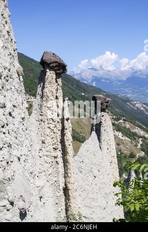 Pyramides d'Euseigne ou formations rocheuses de cheminées de fées dans l'Alp suisse. Les roches restent en équilibre sur l'ancienne moraine érodée du glacier. Un passe routier a été construit à l'uedn Banque D'Images