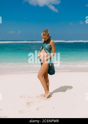 Belle femme enceinte s'attendant à bébé à la plage tropicale Banque D'Images