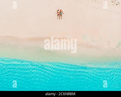 Femme enceinte avec mari se détendre à la plage tropicale avec la mer bleue. Vue aérienne Banque D'Images