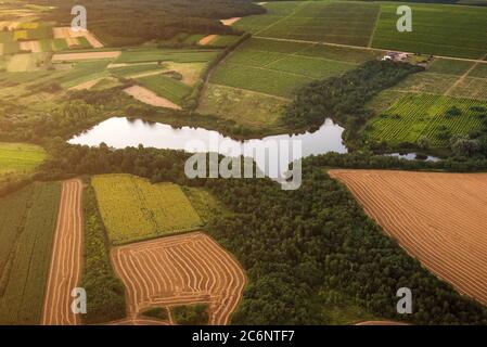 Petit lac entre champs agricoles colorés, vue aérienne Banque D'Images