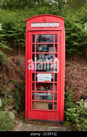 La boîte téléphonique rouge britannique traditionnelle est également utilisée comme une plus grande nourriture pour la communauté locale Banque D'Images