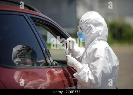 Bucarest / Roumanie - 11 juillet 2020 : un agent de santé utilise un test de RCP (écouvillon nasal et buccal) sur une personne à l'intérieur d'une voiture pour déterminer la présence ou l'abse Banque D'Images