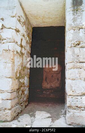 Par une porte dans la structure 33. Statue sans tête de Bird Jaguar IV Palais du roi. Ruines mayas de Yaxchilan. Chiapas, Mexique image Vintage prise sur film Kodak au début des années 1990. Banque D'Images