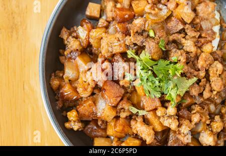 Remuez le porc frits avec de l'oignon et de l'ail et de la sauce au soja noir et de la garniture à la coriandre et du tofu avec lumière naturelle sur le cadre droit et vue sur Flaylay Banque D'Images