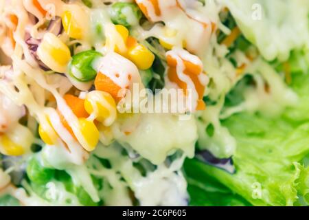 Salade végétarienne ou végétarienne avec garniture de mayonnaise sur le cadre gauche inclure la carotte et la tomate et le maïs et le chou et les pois et la laitue dans le ton vintage Banque D'Images