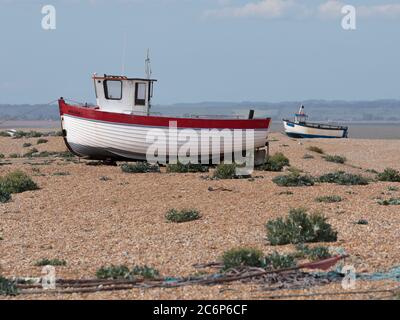 Deux bateaux de pêche sur la plage de Dungeness, une pointe sur la côte du Kent, en Angleterre, ont formé en grande partie une plage de galets. Banque D'Images