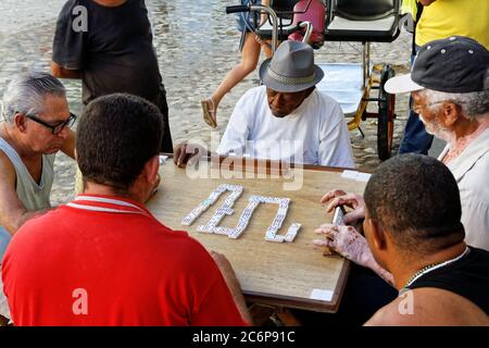 TRINIDAD,CUBA-NOV 23,2013: Vieil homme dans la rue de Trinidad jouant au domino, qui est un jeu typique pour les Cubains qui se rassemblent souvent pour jouer en plein air Banque D'Images