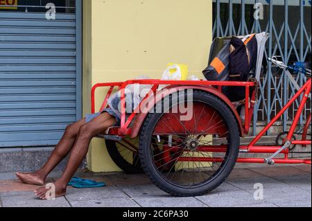 Dormir sans abri sur un vieux pousse-pousse à Bangkok Banque D'Images