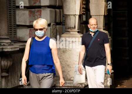 Belgrade, Serbie - 3 juillet 2020 : les personnes portant un masque chirurgical se promusent dans la rue de la ville le jour d'été Banque D'Images