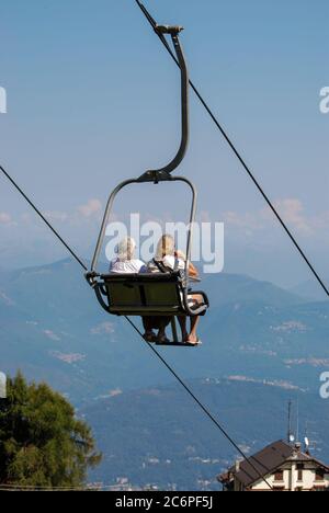 Deux femmes descendent sur un télésiège de Mottarone à Stresa, Lac majeur, Italie Banque D'Images