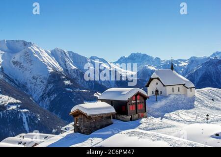 Bettmeralp, Suisse - février 16. 2019: Chapelle Maria in Snow (Kapelle zum Schnee) avec deux anciens chalets - l'architecture historique dans l'a suisse Banque D'Images