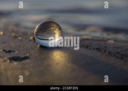 Magnifique lever de soleil capturé à travers une boule d'objectif sur une plage. Finlande. Golfe de Finlande. . Photo de haute qualité Banque D'Images