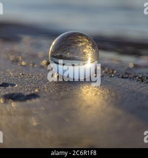 Magnifique lever de soleil capturé à travers une boule d'objectif sur une plage. Finlande. Golfe de Finlande. . Photo de haute qualité Banque D'Images