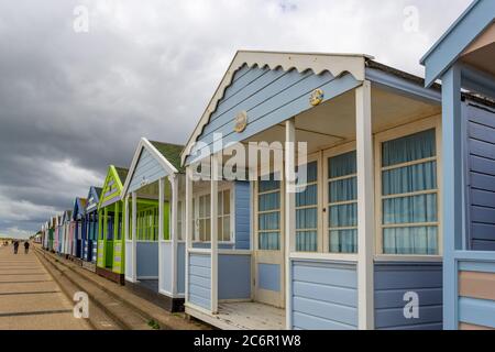 Cabines de plage en bois peintes en couleurs sur la côte du Suffolk Banque D'Images