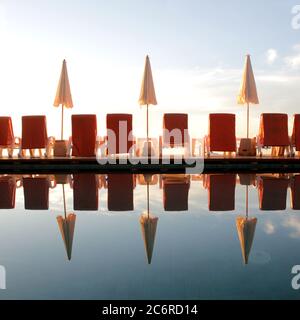 parasol et chaise autour de la piscine près de la plage Banque D'Images