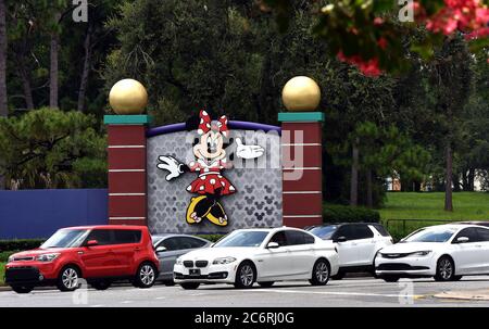 Lake Buena Vista, États-Unis. 11 juillet 2020. Une voiture passe devant un panneau indiquant Minnie Mouse à l'entrée de Walt Disney World le jour où des parties du parc à thème, y compris le Royaume magique, ont été rouvertes aux clients après avoir été fermées depuis la mi-mars en raison de la pandémie du coronavirus. Les cas de COVID-19 sont en hausse en Floride avec plus de 10,000 nouveaux cas et 95 décès liés à la COVID signalés aujourd'hui. Crédit : SOPA Images Limited/Alamy Live News Banque D'Images