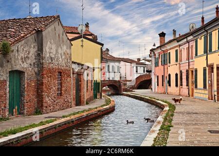 Comacchio, Ferrare, Emilie-Romagne, Italie: Paysage urbain avec des maisons colorées, canal et ponts dans la vieille ville connue sous le nom de petite Venise Banque D'Images