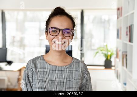 Portrait de la femme d'affaires biraciale souriante au bureau Banque D'Images