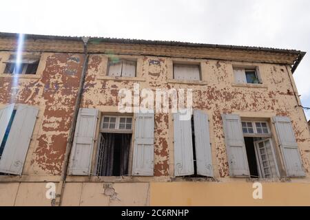 Vieille maison aux intempéries peinture écaillée ouvrir les fenêtres Banque D'Images