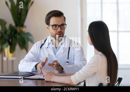 Jeune homme médecin consultant femme à la réunion en clinique Banque D'Images