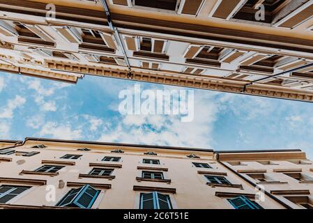 Vue de dessous de deux bâtiments typiquement italiens et ciel bleu avec petits nuages blancs Banque D'Images